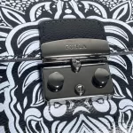 Close-up of the dark push-lock closure on Furla black and white printed leather