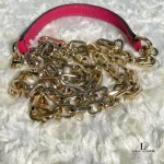 Tory Burch coral pink leather clutch with gold-tone chain, close-up of the gold-tone chain