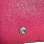 Tory Burch coral pink leather clutch with gold-tone chain, close-up of the clasp and pink lining