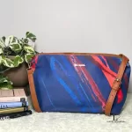Desigual blue multicolour painterly tote bag, styled on a shelf