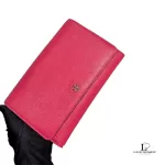 Tory Burch coral pink leather clutch with gold-tone chain, held in hand