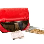 Furla red suede and leather clutch with gold-tone chain, laid out with chain and accessories