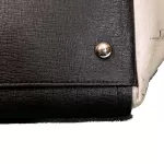 Furla tri-colour two-way handbag in black, white and maroon, close-up of base corner and stud