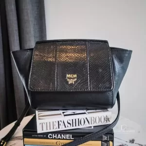 Pre-loved MCM black leather crossbody bag with scale-like flap and gold logo, front view – secondhand designer, NZ