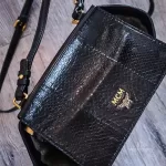 MCM black leather crossbody bag with scale-like flap and gold logo, view 27