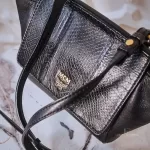 MCM black leather crossbody bag with scale-like flap and gold logo, view 9