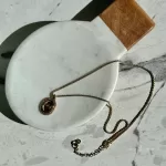 Pre-loved Christian Dior oval 'CD' gold-tone pendant necklace, front view – secondhand designer, NZ