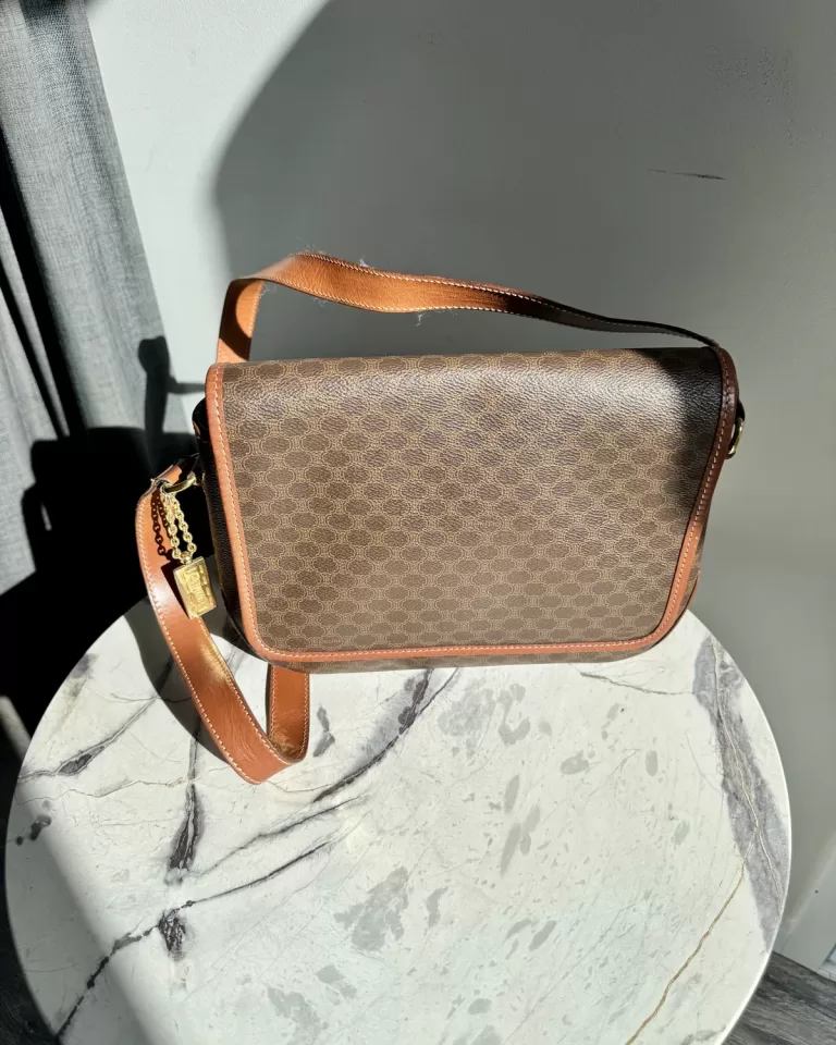 Vintage monogram leather crossbody bag on a marble pedestal